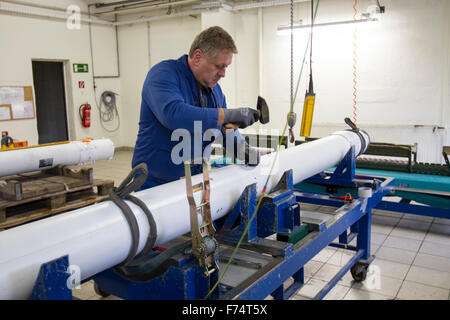HANDOUT - A handout picture made available on 25 November 2015 by the German armed forces (Bundeswehr) shows an employee of the company Nammo Buck GmbH working on the munition of a M26 MLRS multiple missile launcher in Pinnow, Germany, 25 November 2015. Some 25 years after the end of the Cold War, the last batch of cluster munition of the German armed forces has been dismantled. Employees of a munitions disposal company disassembled the remaining missiles in Pinnow. Photo: JANA NEUMANN/Bundeswehr (ATTENTION EDITORS: FOR EDITORIAL USE ONLY IN CONNECTION WITH CURRENT REPORTING/ MANDATORY CRED Stock Photo