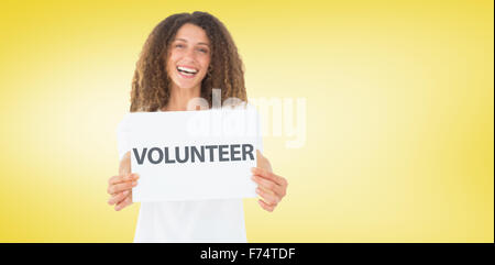 Composite image of smiling volunteer showing a poster Stock Photo