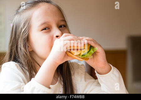 Asian American girl eating burger Stock Photo