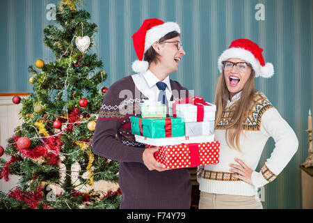 Composite image of geeky hipster couple holding presents Stock Photo