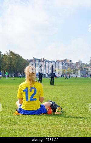 Girl on a break from a soccer game sitting in a park Stock Photo