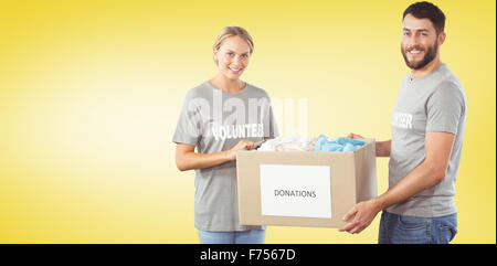 Composite image of portrait of smiling volunteer holding clothes donation box Stock Photo