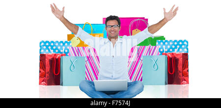 Composite image of successful man with laptop sitting isolated on white background Stock Photo