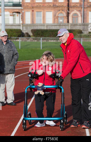 Great Yarmouth, UK. 25th November 2015. Great Yarmouth woman Lisa Borrett, who has cerebral palsy, defeats medical sceptics by learning to walk after a life in a wheelchair. Completing the longest walk of her life and her first outdoors to raise money for local charity Centre 81 and her own enterprise Life Takes Two, 34 year old Lisa even manages a lap of honour around the quarter mile athletics track at the Wellesley recreation Ground in Great Yarmouth. Credit:  Adrian Buck/Alamy Live News Stock Photo