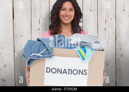 Composite image of volunteer holding clothes donation box Stock Photo