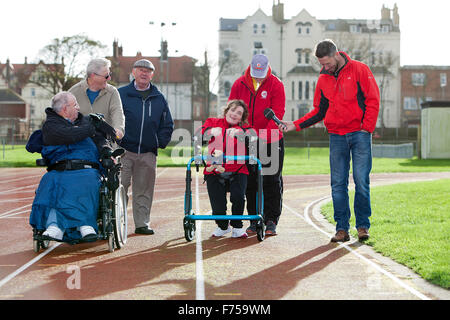 Great Yarmouth, UK. 25th November 2015. Great Yarmouth woman Lisa Borrett, who has cerebral palsy, defeats medical sceptics by learning to walk after a life in a wheelchair. Completing the longest walk of her life and her first outdoors to raise money for local charity Centre 81 and her own enterprise Life Takes Two, 34 year old Lisa even manages a lap of honour around the quarter mile athletics track at the Wellesley recreation Ground in Great Yarmouth. Credit:  Adrian Buck/Alamy Live News Stock Photo