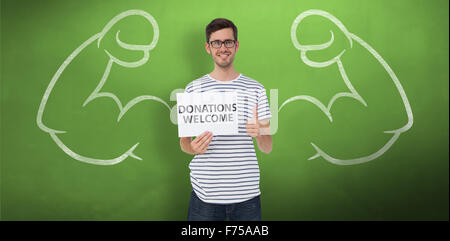 Composite image of man holding a donation welcome note while gesturing thumbs up Stock Photo