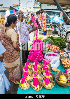 Flower seller selling garlands for temple offerings outside Kapaleeswarar Temple, a Hindu temple of Shiva located in Mylapore, Chennai, Tamil Nadu Stock Photo