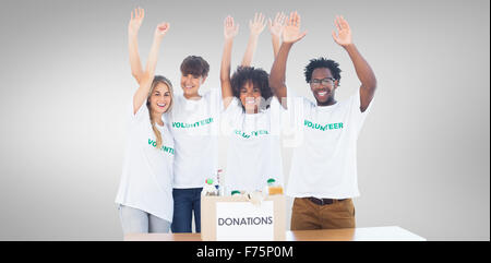 Composite image of volunteers raising their arms Stock Photo