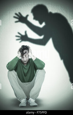 Composite image of sad casual man sitting with hand on head Stock Photo