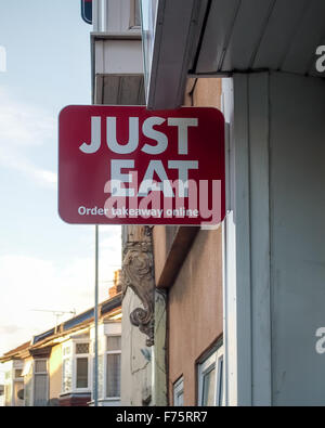 A takeaway with a Just Eat sign outside advertising online ordering Stock Photo
