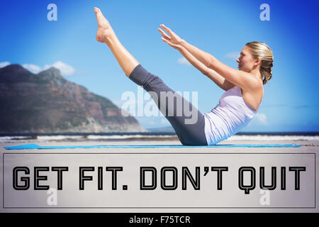 Composite image of focused fit blonde doing yoga on the beach Stock Photo