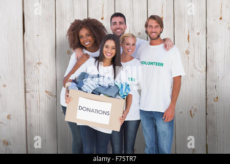 Composite image of happy group of volunteers holding donation box Stock Photo