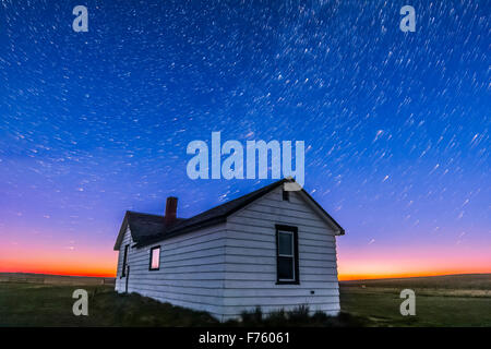 Circumpolar star trails at dawn over the historic Butala homestead at the Old Man on His Back Prairie and Heritage Conservation Stock Photo