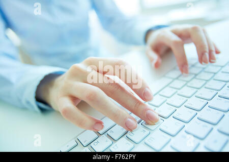 Female office worker typing on the keyboard Stock Photo