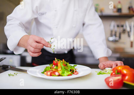 Male chef garnishing dish at the kitchen Stock Photo
