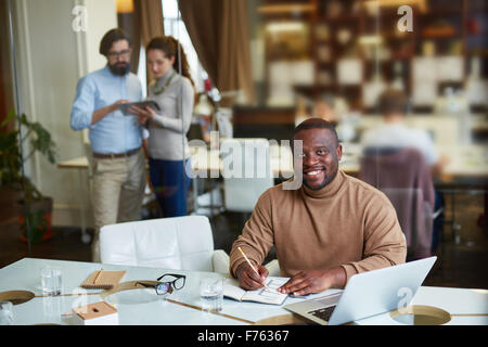 Happy African-American businessman planning work in office Stock Photo