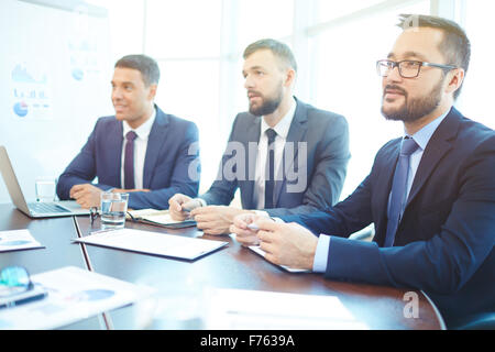 Group of successful young businessmen listening to lecture Stock Photo