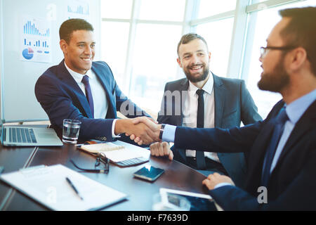Happy businessmen handshaking after negotiation in office Stock Photo