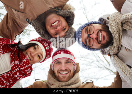 Young cheerful friends in winterwear looking at camera Stock Photo
