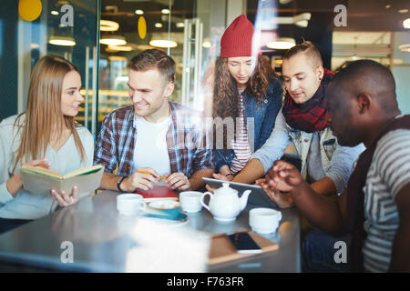 Teenage friends doing homework in cafe Stock Photo