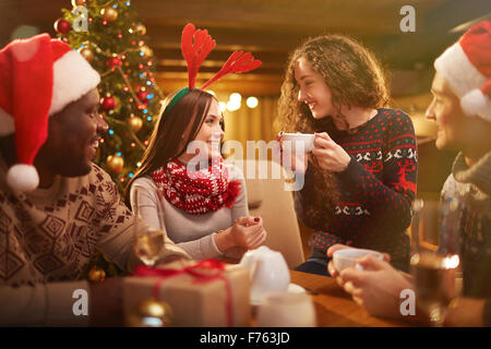 Friendly guys and girls having good Christmas evening Stock Photo