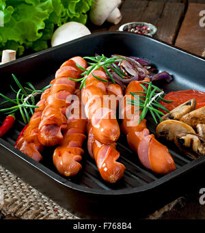 Grilled sausages with vegetables on a frying pan Stock Photo
