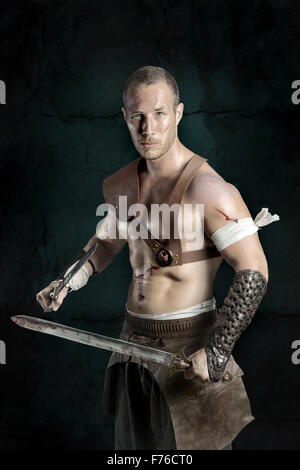 Gladiator posing isolated in a dark background Stock Photo - Alamy