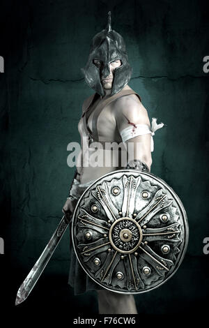 Gladiator posing isolated in a dark background Stock Photo - Alamy