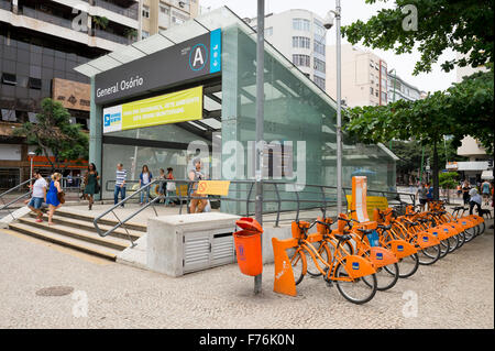 RIO DE JANEIRO, BRAZIL - OCTOBER 22, 2015: Trademark orange bicycles from the Bike Rio public sharing system stand at the Metro. Stock Photo