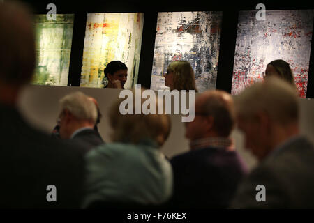 Customers follow an art auction at the Van Ham auction house in front of paintings by the artist Gerhard Richter in Cologne, Germany, 26 November 2015. Pieces by Gerhard Richter are being auctioned in support of the Duesseldorf-based street magazine 'fiftyfifty' at the Van Ham auction house. Photo: OLIVER BERG/dpa