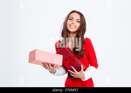 Cheerful pleased charming young woman in red santa claus costume with hood holding opened present on white background Stock Photo