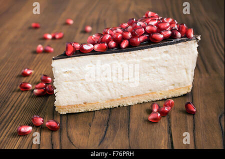 Cheesecake with pomegranate on wooden table Stock Photo
