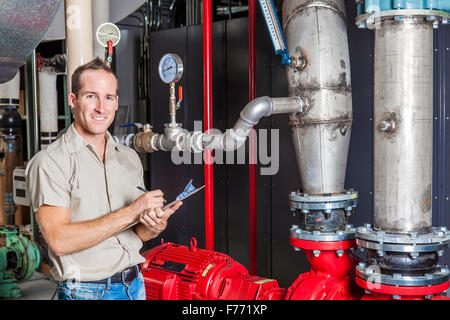 Technician inspecting heating system in boiler room Stock Photo