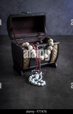 An antique engraved wooden jewelry box in the form of a treasure chest Stock Photo