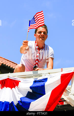 Patriotic young man waves a US flag on July 4th celebrating his independence Stock Photo