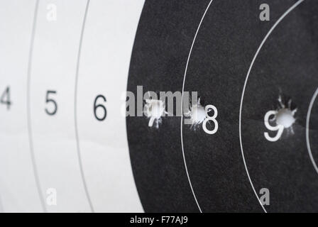 closeup of paper shooting target with bullet holes and airgun pellets ...