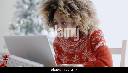 Excited woman shopping online for Xmas bargains Stock Photo