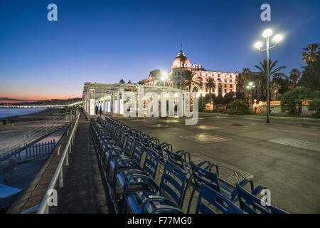 Hotel Negresco on Promenade des Anglais in Nice, blue chairs in a row,  twilight, Provence-Alpes-Cote d'Azur, France Stock Photo