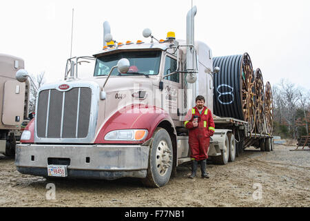 Two American Peterbilt 379 semi trucks hauling reels of HDPE plastic pipe on a flatbed trailer for the oil industry and fracking sites in the USA Stock Photo