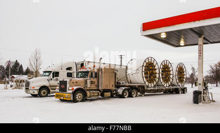 An American Peterbilt 379 semi truck hauling reels of HDPE plastic pipe on a flatbed trailer for the oil industry and fracking sites in the USA Stock Photo