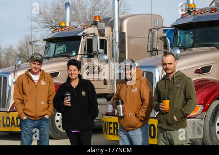 Foreign truck drivers pose beside their 'Watt and Stewart' Canadian company peterbilt trucks in Dalhart, Texas, USA Stock Photo