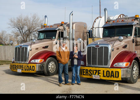 Foreign truck drivers pose beside their 'Watt and Stewart' Canadian company peterbilt trucks in Dalhart, Texas, USA Stock Photo