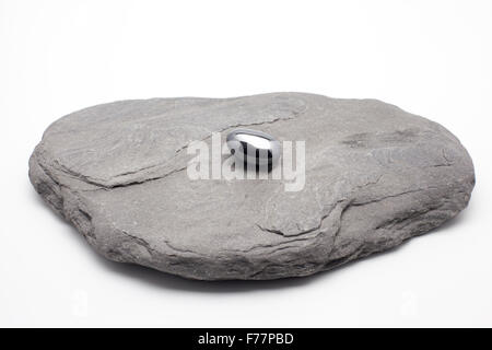 Black Hematite Pebble on a stone Stock Photo