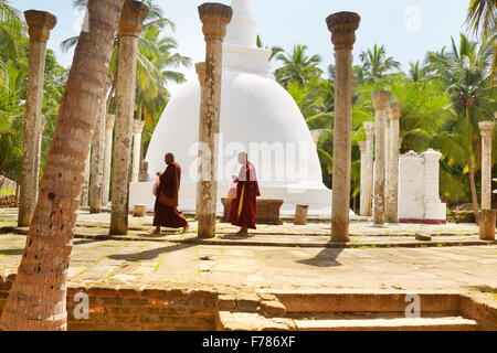 Sri Lanka - Mihintale Temple, monks in front of the stupa, Ambasthale Dagoba, UNESCO Stock Photo