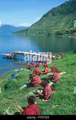Indian women clean & top onions at San Antonio Palopo on Lake Atitlan, Guatemala. Stock Photo