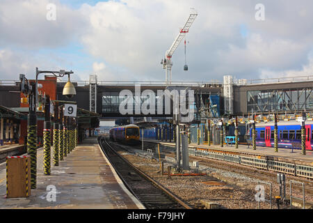 Looking along platform 9 at the over bridge and along the lines towards Didcot with a DMU in the platform adjacent. Stock Photo