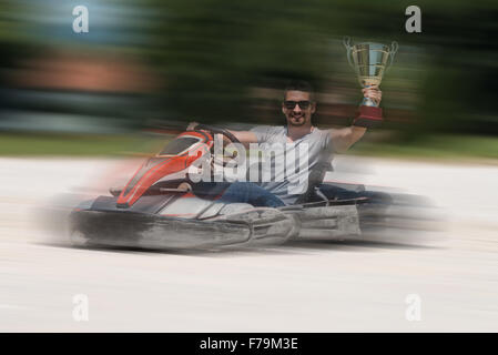 Young Man Is Driving Go-Kart Car With Speed In A Playground Racing Track - Go Kart Is A Popular Leisure Motor Sports Stock Photo