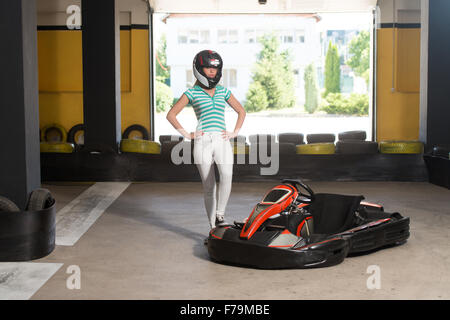 Young Woman Is Driving Go-Kart Car With Speed In A Playground Racing Track - Go Kart Is A Popular Leisure Motor Sports Stock Photo