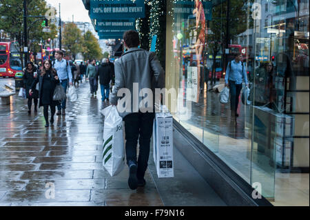 - London, UK.  27 November 2015.  A man walks by clutching a new television and more in Oxford Street, central London, on what is known as 'Black Friday', a day when retailers cut prices in the run up to Christmas.  Retailers had expected large early morning crowds, but they failed to materialise.  Credit:  Stephen Chung / Alamy Live News Stock Photo